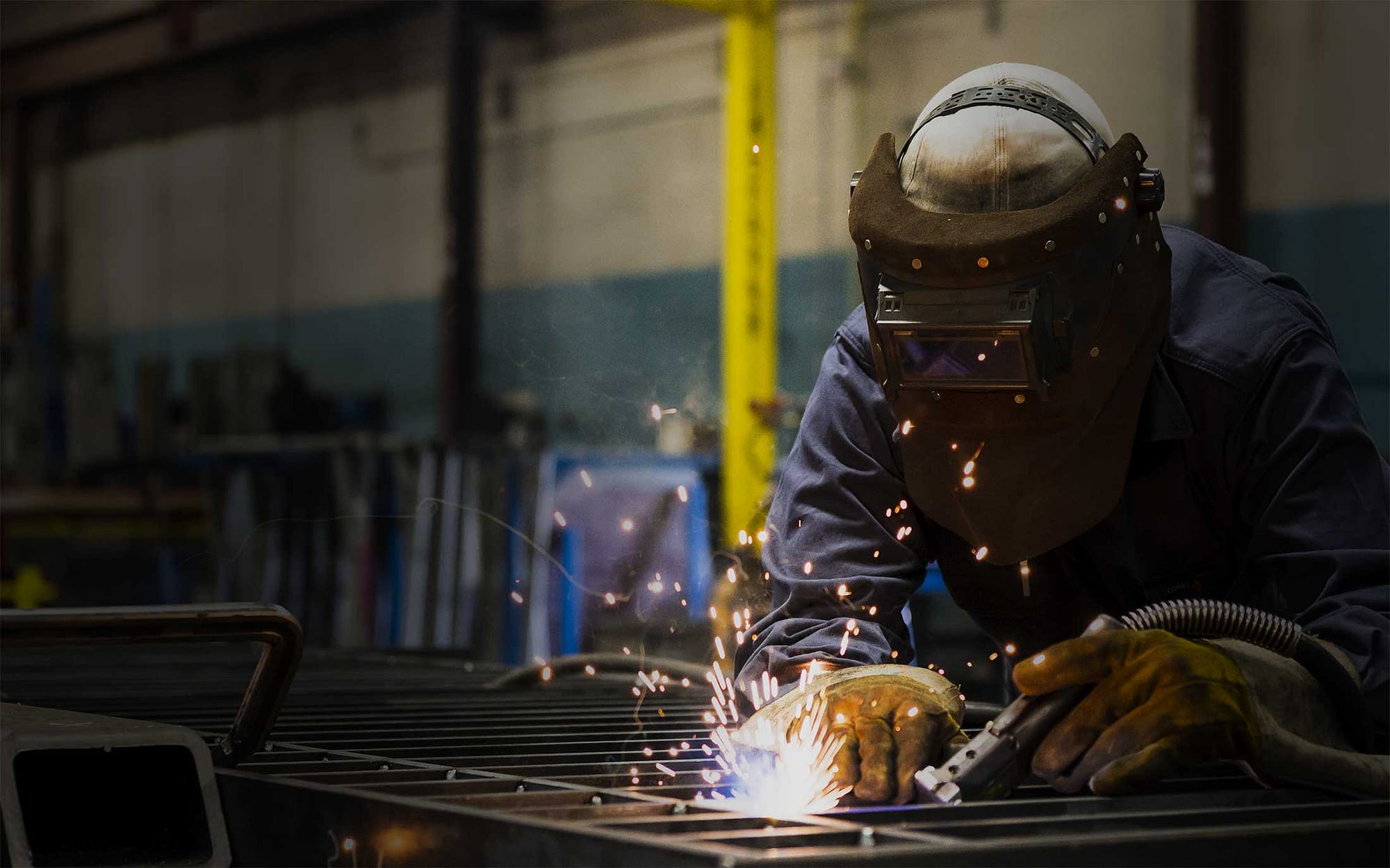 A welder engages in steel fabrication and prepares it for installation.