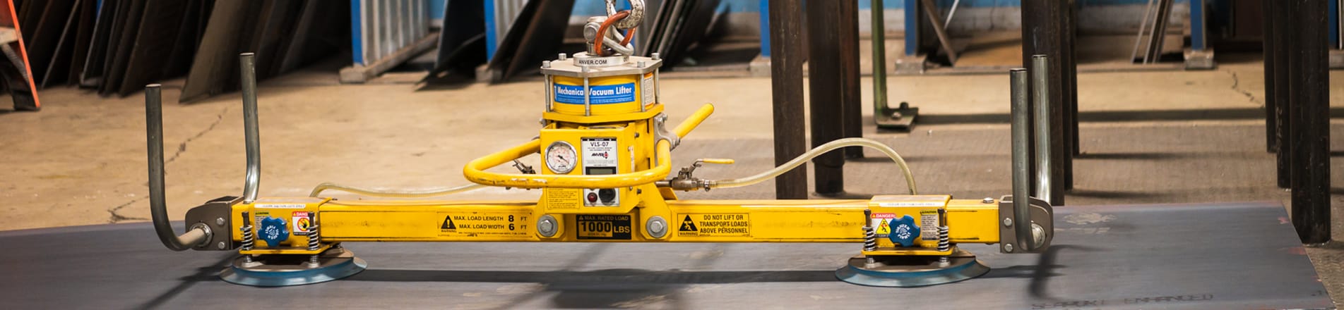 An industrial lifter for steel and metal work sits on a piece of metal.